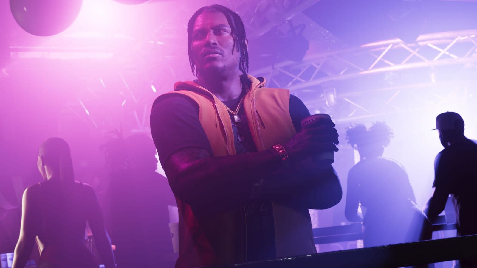 Dre’Quan Priest with his arms crossed in a nightclub lit in purple