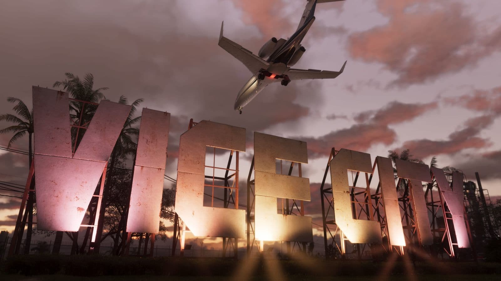 The Vice City sign lit up at sunset as a private jet flies overhead